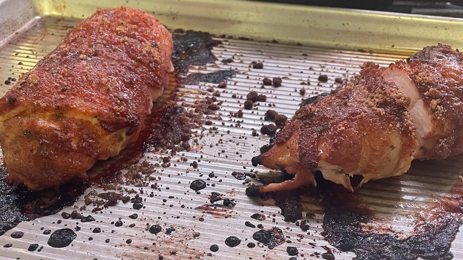 Bacon wrapped chicken on a pan.